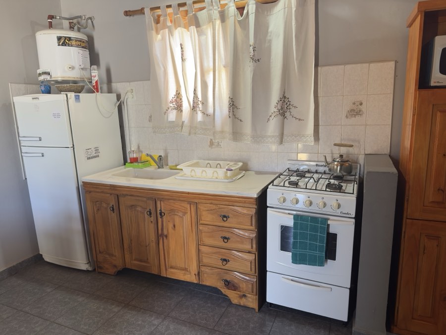 Cocina equipada con heladera, cocina a gas y bajomesada