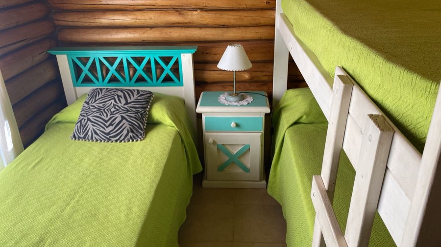 Dos camas individuales con mesa de luz en el dormitorio