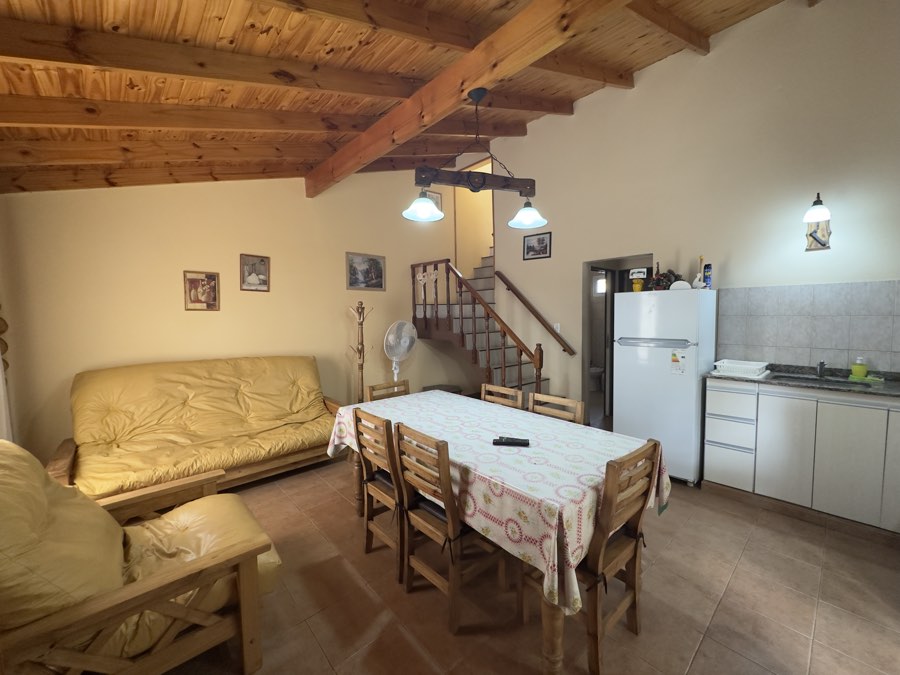 Estar comedor en planta baja con sofá cama y escalera
