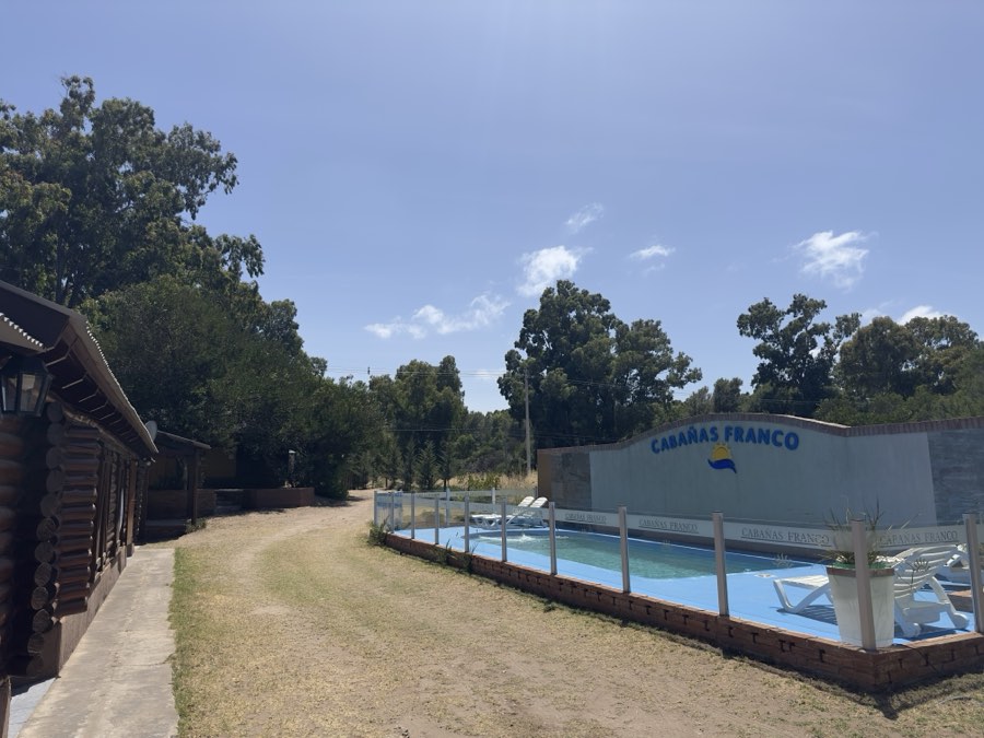 Pileta del complejo con reposeras en un día despejado